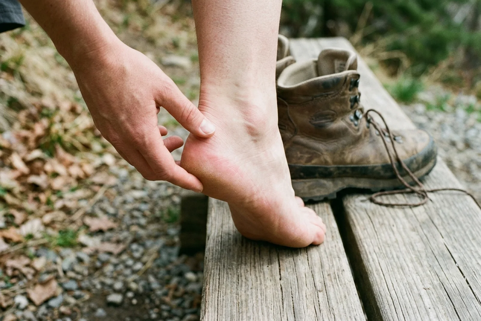 A walker checking the back of an intact heel beside a boot that has been taken off